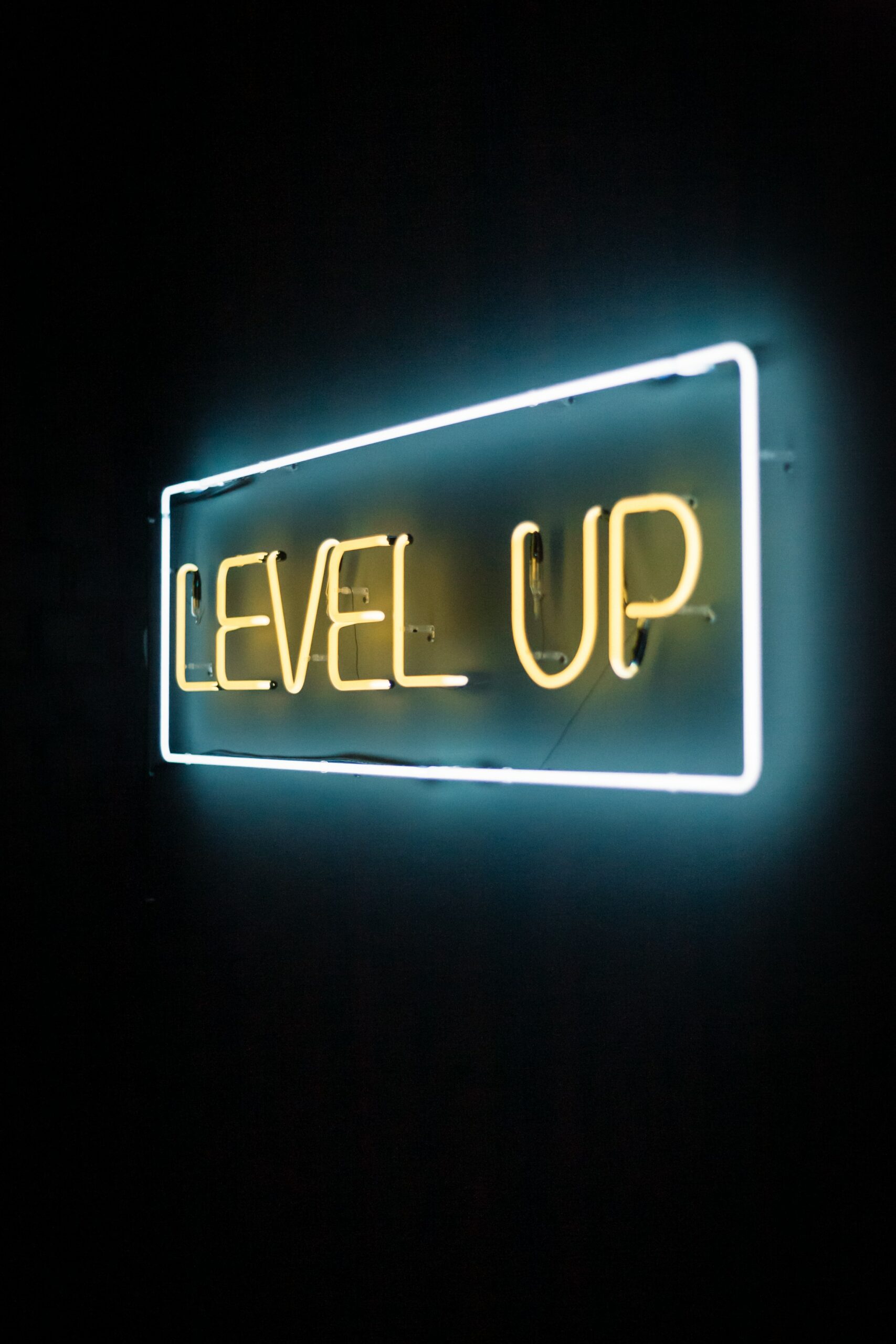 yellow and white neon text reads "level up" on a brick wall